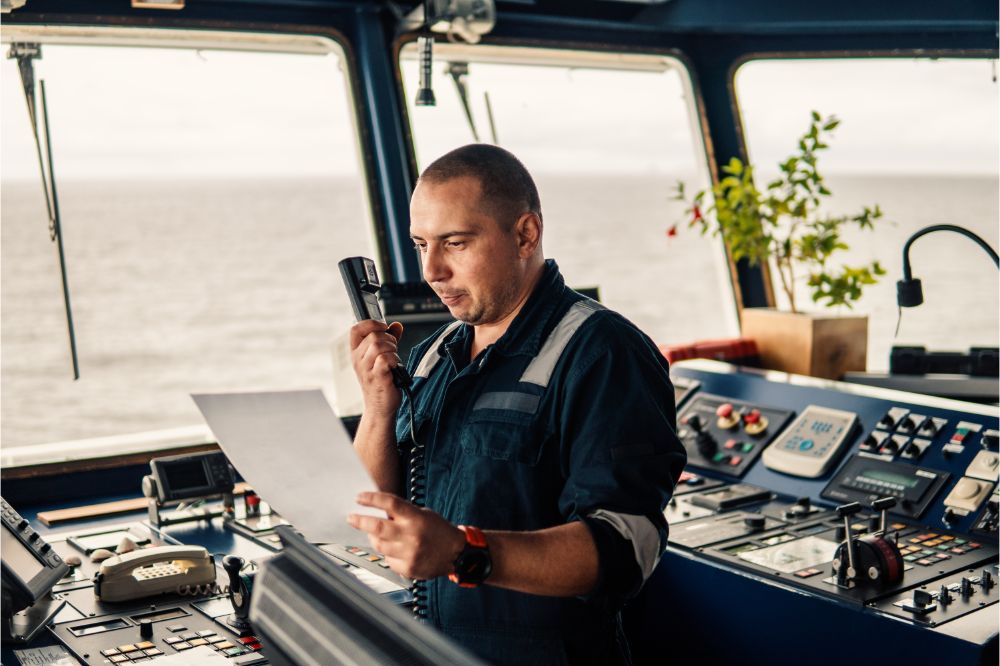 marine navigational officer is reporting by VHF radio during navigation watch