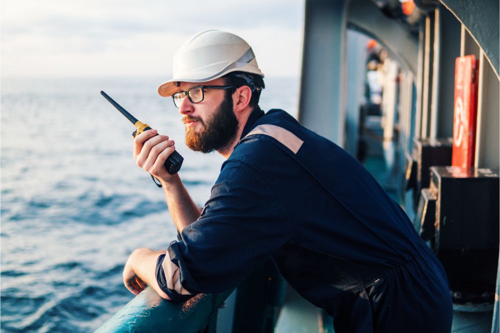 deck officer holds VHF walkie-talkie radio in hands