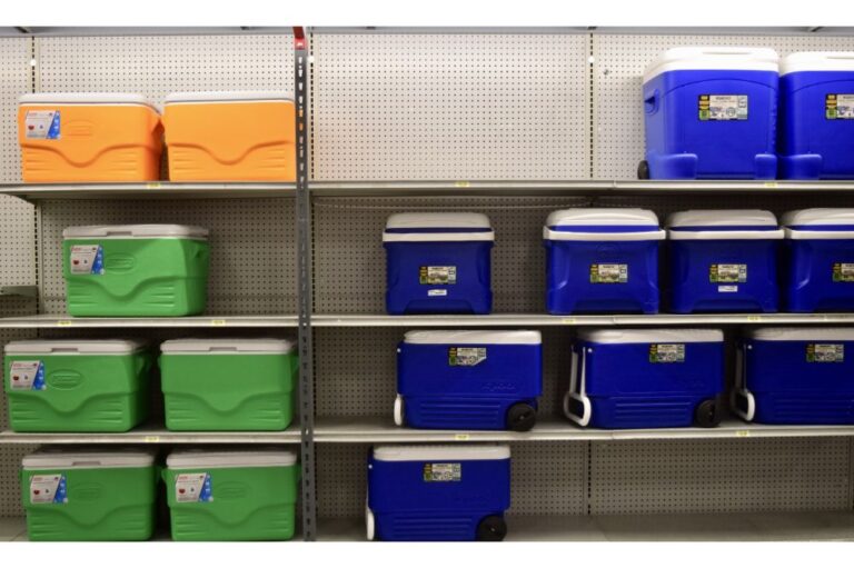 Lot of green, blue and yellow ice chest coolers on shelves with empty spaces